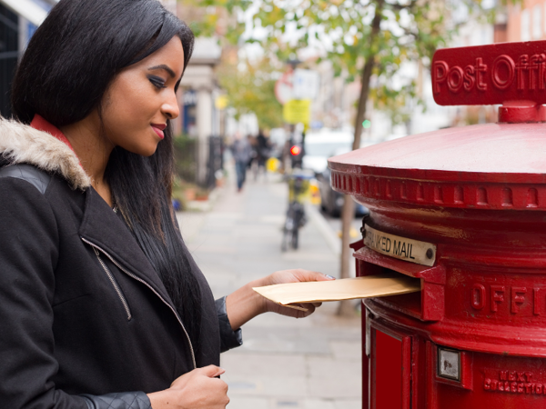Person putting envelope in post box
