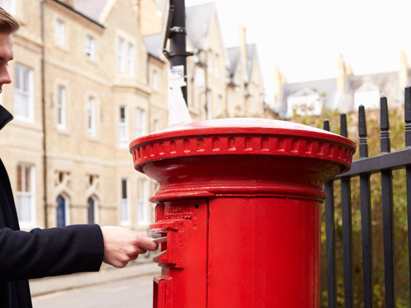 Man putting envelope in letterbox